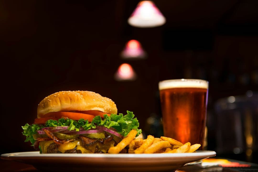 Cheeseburger with fries and a pint of beer at a pub